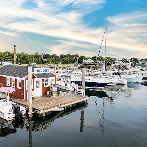 A marina with boats docked, featuring a red building labeled 